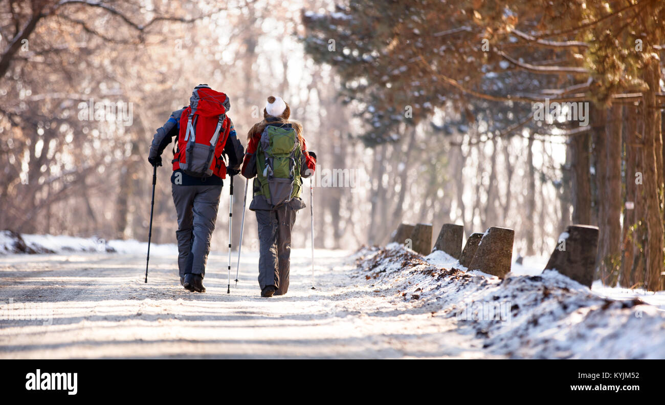 Hikers couple with backpacks in snowy forest, back view Stock Photo - Alamy