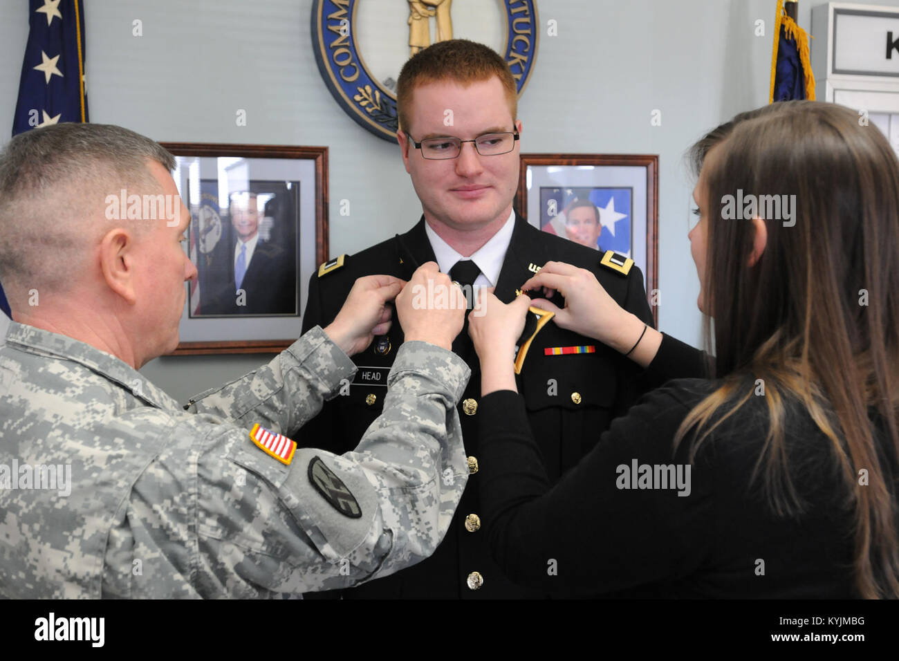 Chaplain (Col.) David Graetz and Marla Head attach new branch insignia to the uniform of Chaplain (Capt.) Steven Head during a promotion ceremony in Frankfort, Ky., Feb. 20, 2013. (KYNG photo by Sgt. Scott Raymond) Stock Photo