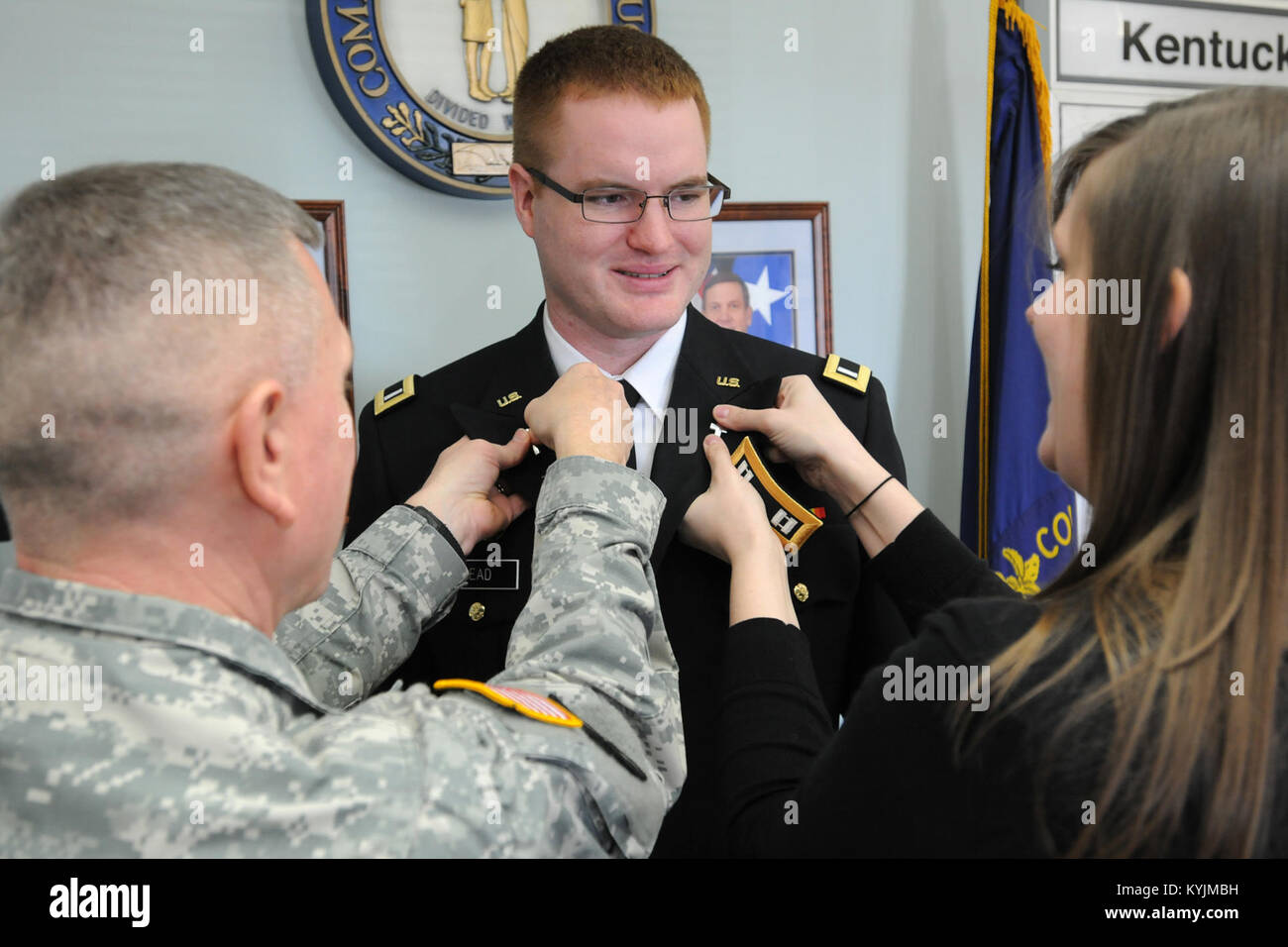 Chaplain (Col.) David Graetz and Marla Head attach new branch insignia to the uniform of Chaplain (Capt.) Steven Head during a promotion ceremony in Frankfort, Ky., Feb. 20, 2013. (KYNG photo by Sgt. Scott Raymond) Stock Photo