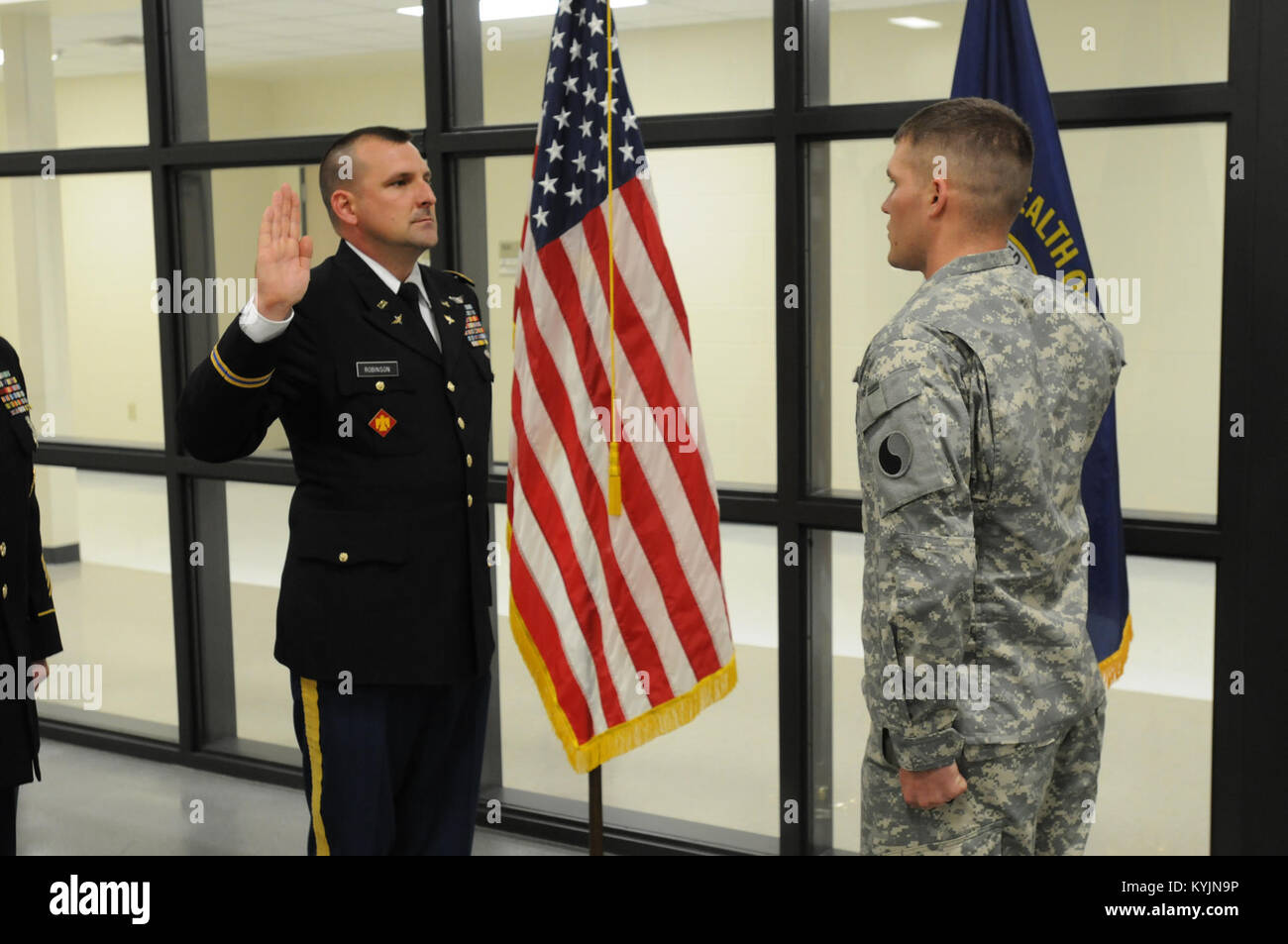 Spc. Daniel Burkemeir of the 1204th Aviation Support Battalion re-enlists in the Kentucky National Guard with the help of unit commander, Maj. Phillip Robinson, May 10, 2013, in Burlington, Ky. (U.S. Army National Guard photo by Staff Sgt. Scott Raymond) Stock Photo
