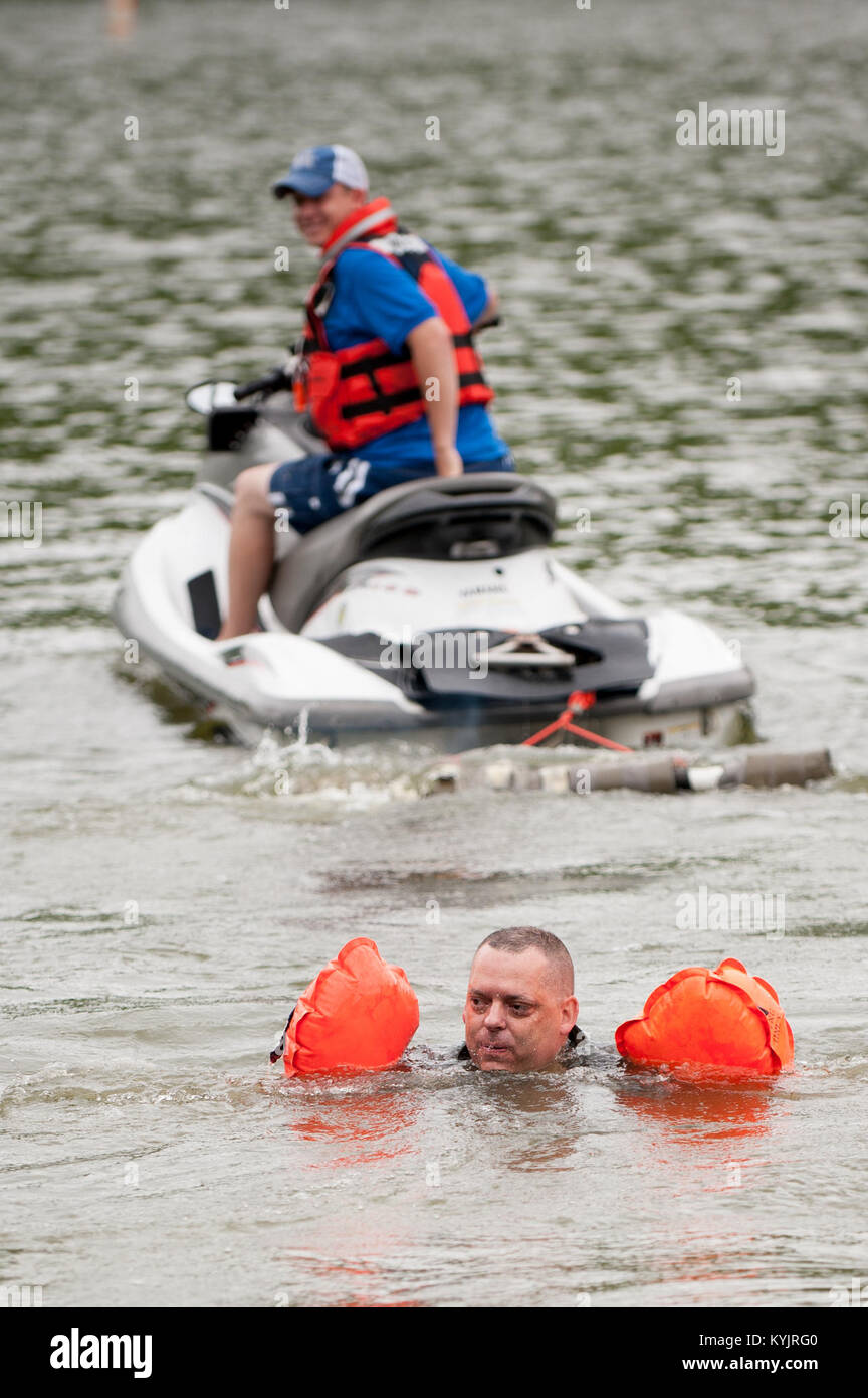 Maj. Todd Franks, a pilot in the Kentucky Air National Guard’s 165th Airlift Squadron, surfaces at Taylorsville Lake in Taylorsville, Ky., June 5, 2014, after extricating himself from a parachute harness being pulled by a personal watercraft. The exercise is designed to simulate what could happen to aircrew members who’ve parachuted into water when the wind catches their open chutes and drags them across the surface, posing the risk of drowning. (U.S. Air National Guard photo by Maj. Dale Greer) Stock Photo