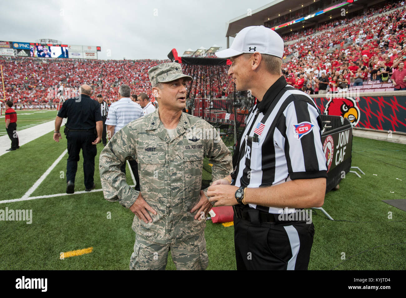 Air Force Brig. Gen. Warren Hurst, the Kentucky National Guard's assistant adjutant general for Air and commander of the Kentucky Air National Guard, speaks with head referee Jeff Heaser at Papa John’s Cardinal Stadium in Louisville, Ky., prior to the University of Louisville – Murray State football game Sept. 6, 2014. The game, billed as Military Appreciation Day, began with a coin toss executed Hurst. (U.S. Air National Guard photo by Maj. Dale Greer/Released) Stock Photo