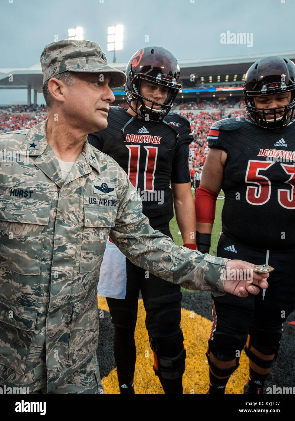 Air Force Brig. Gen. Warren Hurst, the Kentucky National Guard's assistant adjutant general for Air and commander of the Kentucky Air National Guard, executes the coin toss at Papa John’s Cardinal Stadium in Louisville, Ky., to begin the University of Louisville – Murray State football game Sept. 6, 2014. The game was billed as Military Appreciation Day. (U.S. Air National Guard photo by Maj. Dale Greer/Released) Stock Photo