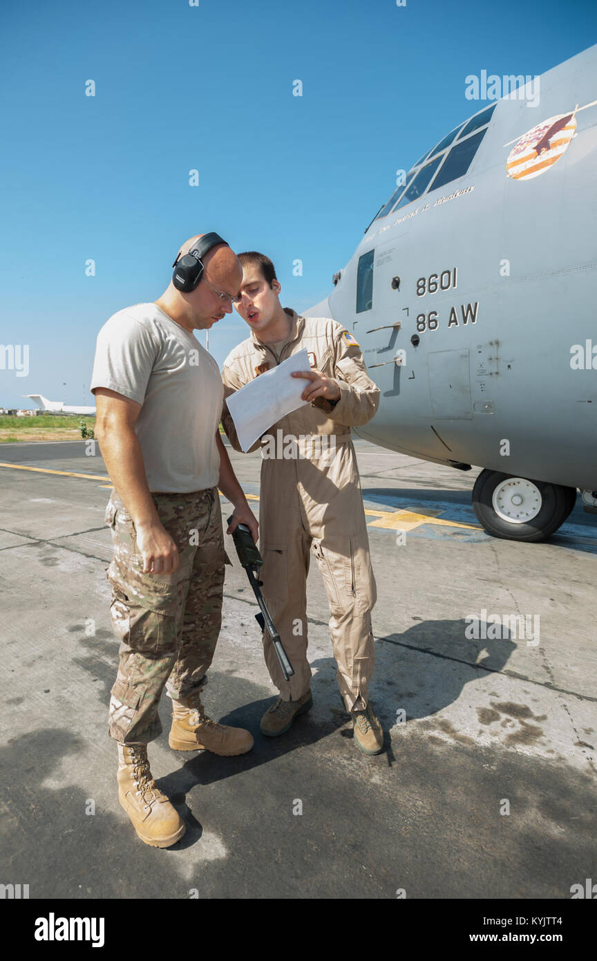 U.S. Air Force Tech. Sgt. Jarrod Blanford, an aerial porter from the Kentucky Air National Guard’s 123rd Contingency Response Group (left), reviews a cargo manifest with U.S. Air Force Airman 1st Class Evan Kuehl, a loadmaster from the 86th Airlift Wing, prior to the departure of a C-130 Hercules from Léopold Sédar Senghor International Airport in Dakar, Senegal, Oct. 22, 2014. The flight is bound for Liberia, carrying whole blood and U.S. Army Soldiers supporting Operation United Assistance, the U.S. Agency for International Development-led, whole-of-government effort to respond to the Ebola  Stock Photo