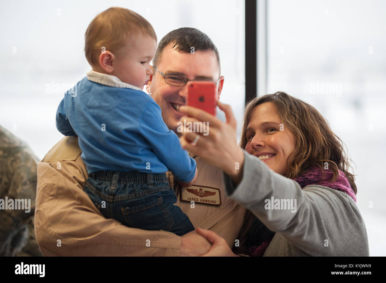 Maj. Jared Hawkins, a C-130 Hercules navigator in the 123rd Airlift Wing, poses for a selfie with his son and wife, Jaime and Lairkin Hawkins, at the Kentucky Air National Guard Base in Louisville, Ky., Feb. 21, 2015. Hawkins is deploying to the Persian Gulf in support of Operation Freedom's Sentinel, during which more than 110 members of the Kentucky Air Guard will fly troops and cargo across the U.S. Central Command Area of Responsibility. (U.S. Air National Guard photo by Maj. Dale Greer) Stock Photo