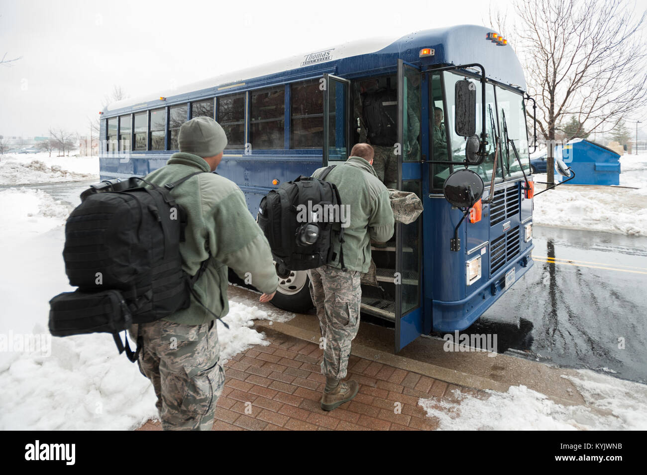 Members of the 123rd Airlift Wing board a bus that will take them to their C-130 Hercules aircraft at the Kentucky Air National Guard Base in Louisville, Ky., Feb. 21, 2015. The Airmen are heading to the Persian Gulf for a four-month deployment in support of Operation Freedom's Sentinel. (U.S. Air National Guard photo by Maj. Dale Greer) Stock Photo
