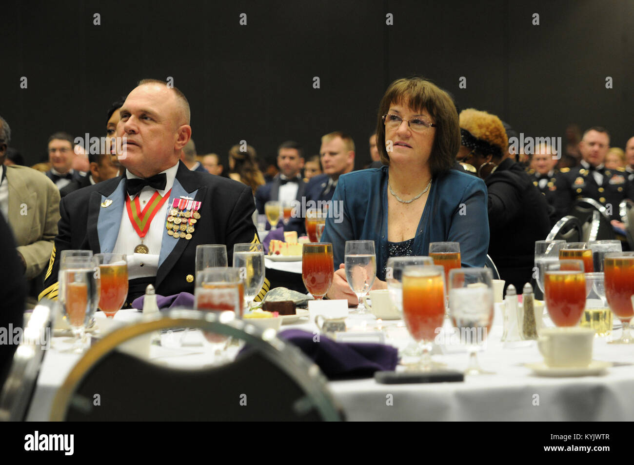 Kentucky National Guard State Command Sgt. Maj. Thomas Chumley and his wife, Wanda, enjoy the remarks made by Sgt. Maj. Gary Smith, 4th Marine Logistics Group command senior enlisted leader, at the 2015 Outstanding Airman and Soldier of the Year Banquet March 14, 2015 at the Kentucky Fair and Exposition Center in Louisville, Kentucky. Smith thanked the Wanda Chumley for her hospitality. The annual awards dinner honors Kentucky's finest Airmen and Soldiers who are recognized by their peers for dedicating themselves to the welfare and security of our nation. (Photo by Sgt. 1st Class Gina Vaile-N Stock Photo