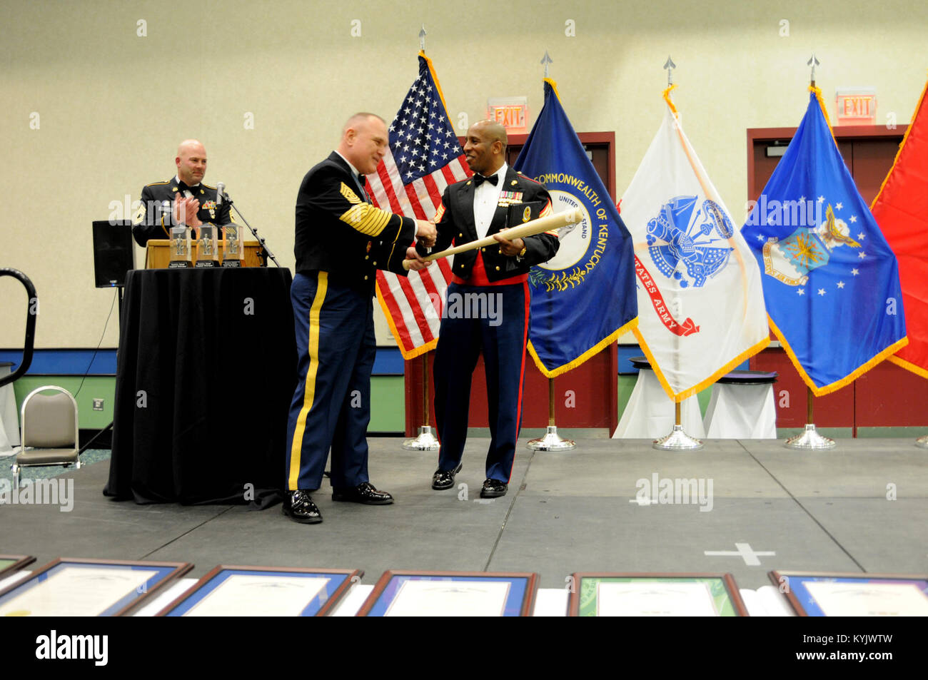 Kentucky National Guard State Command Sgt. Maj. Thomas Chumley presents Sgt. Maj. Gary Smith, 4th Marine Logistics Group command senior enlisted leader, with a custom Louisville Slugger baseball bat in appreciation for his mentorship and presence at the Kentucky National Guard's 2015 Outstanding Airman and Soldier of the Year Banquet March 14, 2015, in Louisville, Kentucky. Smith served alongside Chumley and the Kentucky National Guard's 2nd Battalion, 138th Field Artillery during a 2012 deployment to the Horn of Africa. The annual awards dinner honors Kentucky's finest Airmen and Soldiers who Stock Photo