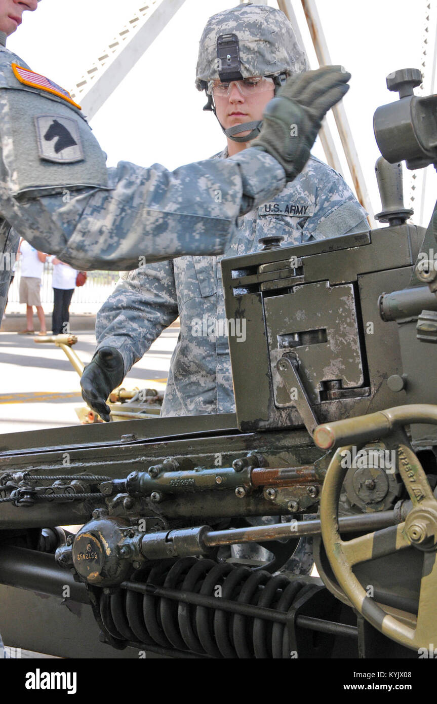 Spc. Tiffany Dirolf, supply specialist for the 138th Field Artillery Brigade, loads a practice round in a 105mm howitzer cannon during the 2015 Thunder Over Louisville, April 18. (Photo by Sgt. Brandy Mort, 133rd MPAD, Kentucky Army NG) Stock Photo