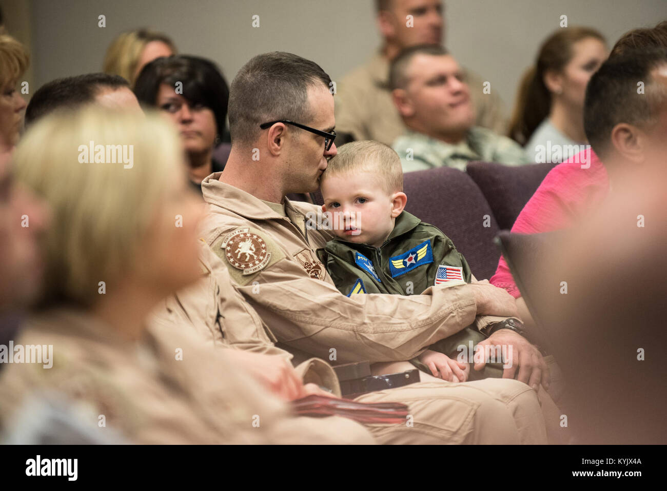 Tech. Sgt. Paul Jones, a C-130 loadmaster in the 123rd Airlift Wing, and his son, Jonathan Paul Jones, attend a briefing at the Kentucky Air National Guard Base in Louisville, Ky., April 24, 2015, prior to Jones' deployment to an undisclosed air base in the Persian Gulf region. Jones and more than 40 other Kentucky Air Guardsmen comprise the third rotation of 123rd Airmen to deploy to the base since February. They will be flying airlift missions throughout the U.S. Central Command Area of Responsibility in support of Operation Freedom's Sentinel, which provides military training and counterter Stock Photo