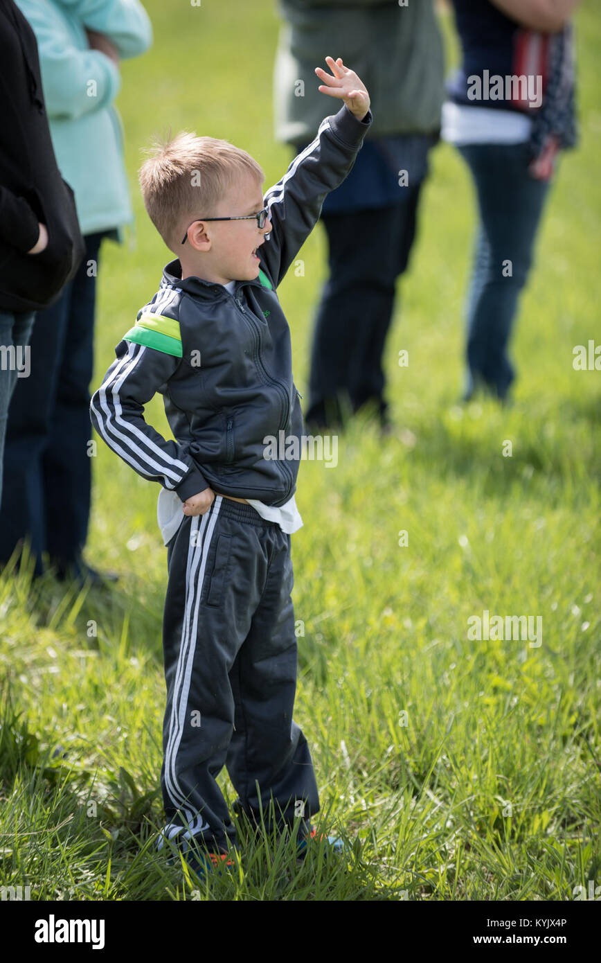 Asher Pentecost, son of Tech. Sgt. Donnie Pentecost of the 123rd Airlift Wing, waves goodbye to his father at the Kentucky Air National Guard Base in Louisville, Ky., April 24, 2015, as a C-130 Hercules aircraft caring more than 40 Airmen departs for deployment to an undisclosed air base in the Persian Gulf region. The Air Guardsmen will support airlift missions throughout the U.S. Central Command Area of Responsibility as part of Operation Freedom's Sentinel, which provides military training and counterterrorism capabilities in Afghanistan. (U.S. Air National Guard photo by Maj. Dale Greer) Stock Photo