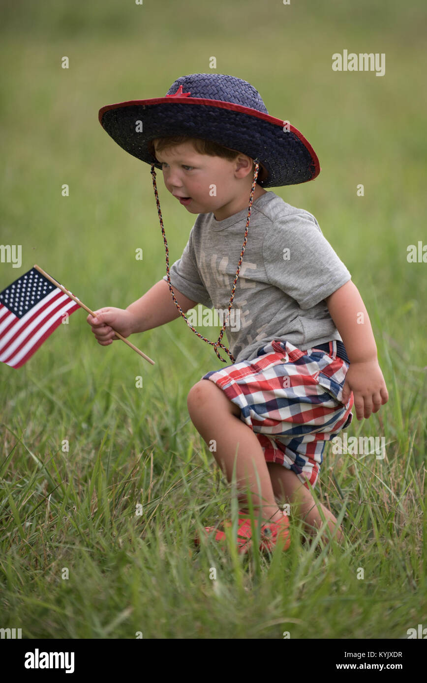 Two-year-old Max Gordon plays in the grass at the Kentucky Air National Guard Base in Louisville, Ky., July 4, 2015, as he waits for his uncle, Master Sgt. Aaron Schalck, to return from a deployment in the Persian Gulf region. Airmen from the Kentucky Air Guard's 123rd Airlift Wing have been supporting Operation Freedom's Sentinel in the U.S. Central Command Area of Responsibility since February. (U.S. Air National Guard photo by Maj. Dale Greer) Stock Photo