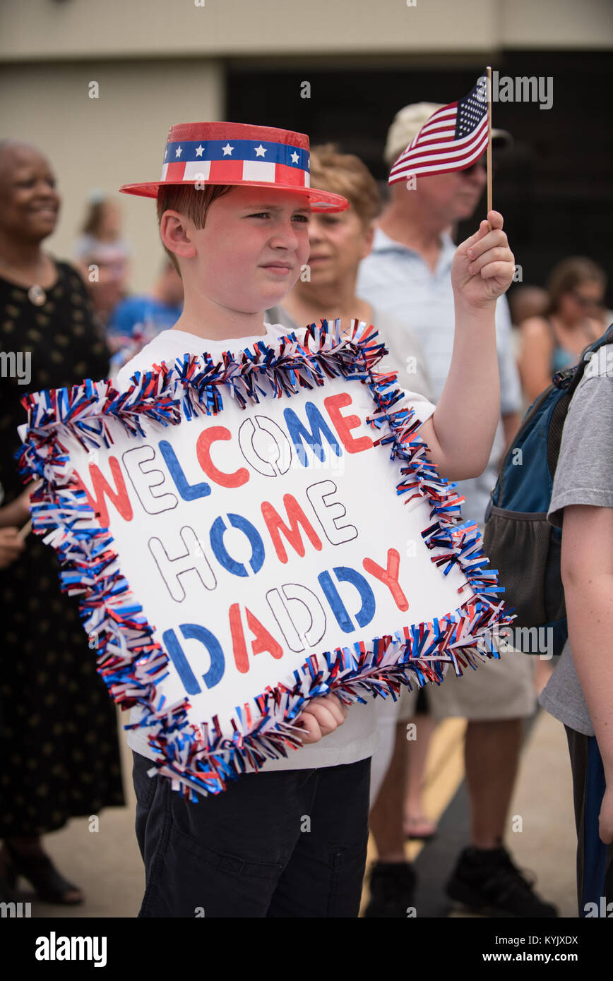 The son of a Kentucky Air National Guardsman waits for his father to step off a C-130 Hercules aircraft at the Kentucky Air National Guard Base in Louisville, Ky., July 4, 2105. The father was one of 39 Kentucky Airmen who returned to the United States following a deployment in the Persian Gulf region, where they've been supporting Operation Freedom's Sentinel since February. (U.S. Air National Guard photo by Maj. Dale Greer) Stock Photo