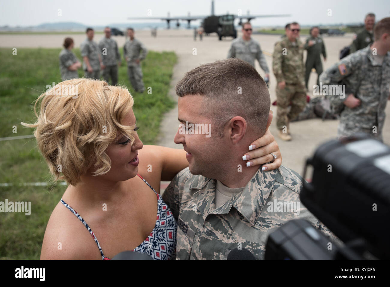 Tech. Sgt. Mike Johnson, a C-130 crew chief in the 123rd Airlift Wing, proposes to his girlfriend, Vanna Jones, on the flight line of the Kentucky Air National Guard Base in Louisville, Ky., July 4, 2015, after returning from a deployment to the Persian Gulf region. Jones said yes. (U.S. Air National Guard photo by Maj. Dale Greer) Stock Photo