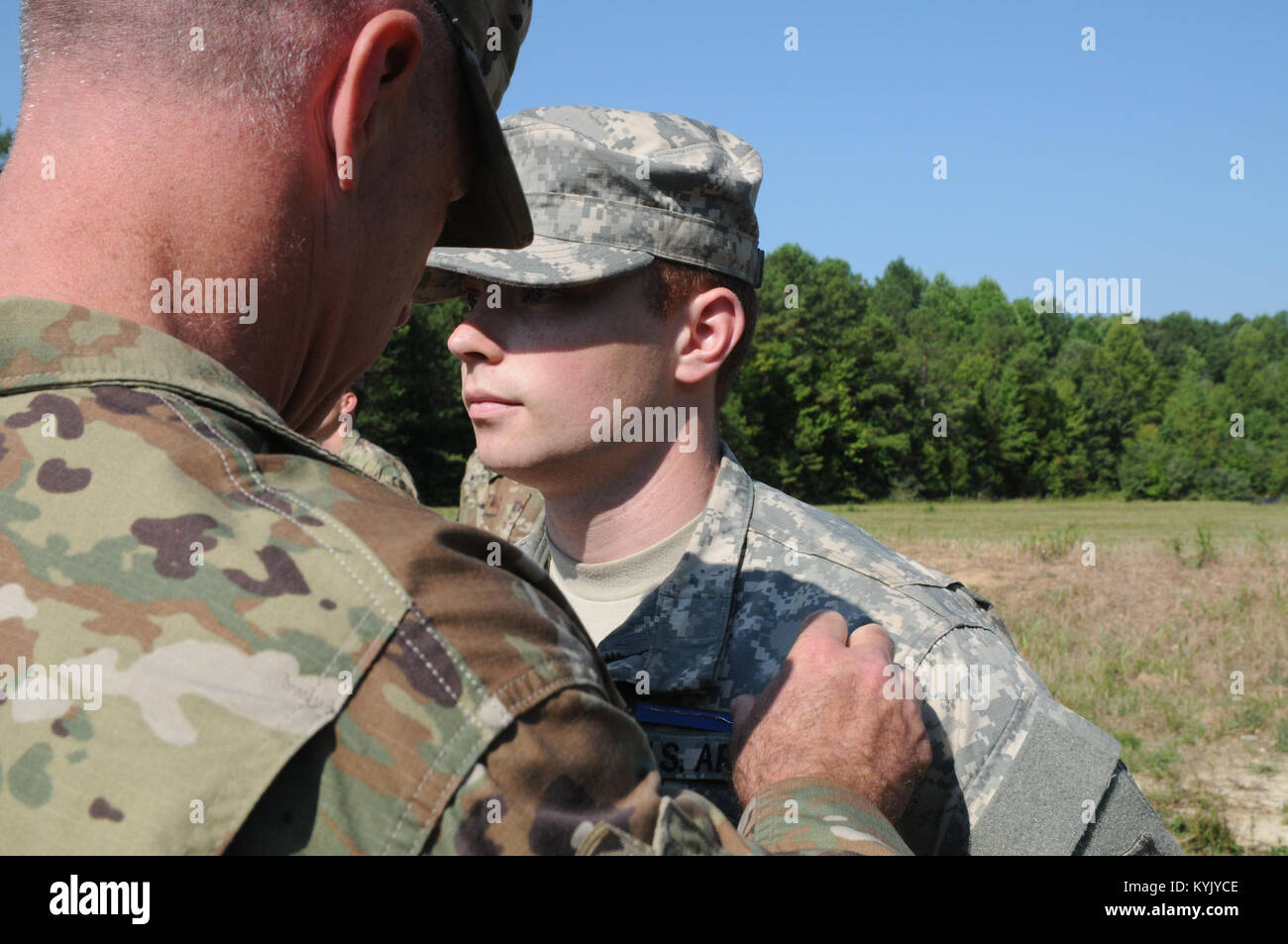 Spc. Adam Dunn right), assigned to 1st Battalion 149th Infantry Regiment, Kentucky National Guard, gets pinned with the Expert Infantry Badge by his Battalion Commander Lt. Col. Eddie Simpson, Aug. 5 through Aug. 10 at Fort Pickett, Va. Dunn was one of three Kentucky Guardsmen to earn the EIB. Stock Photo