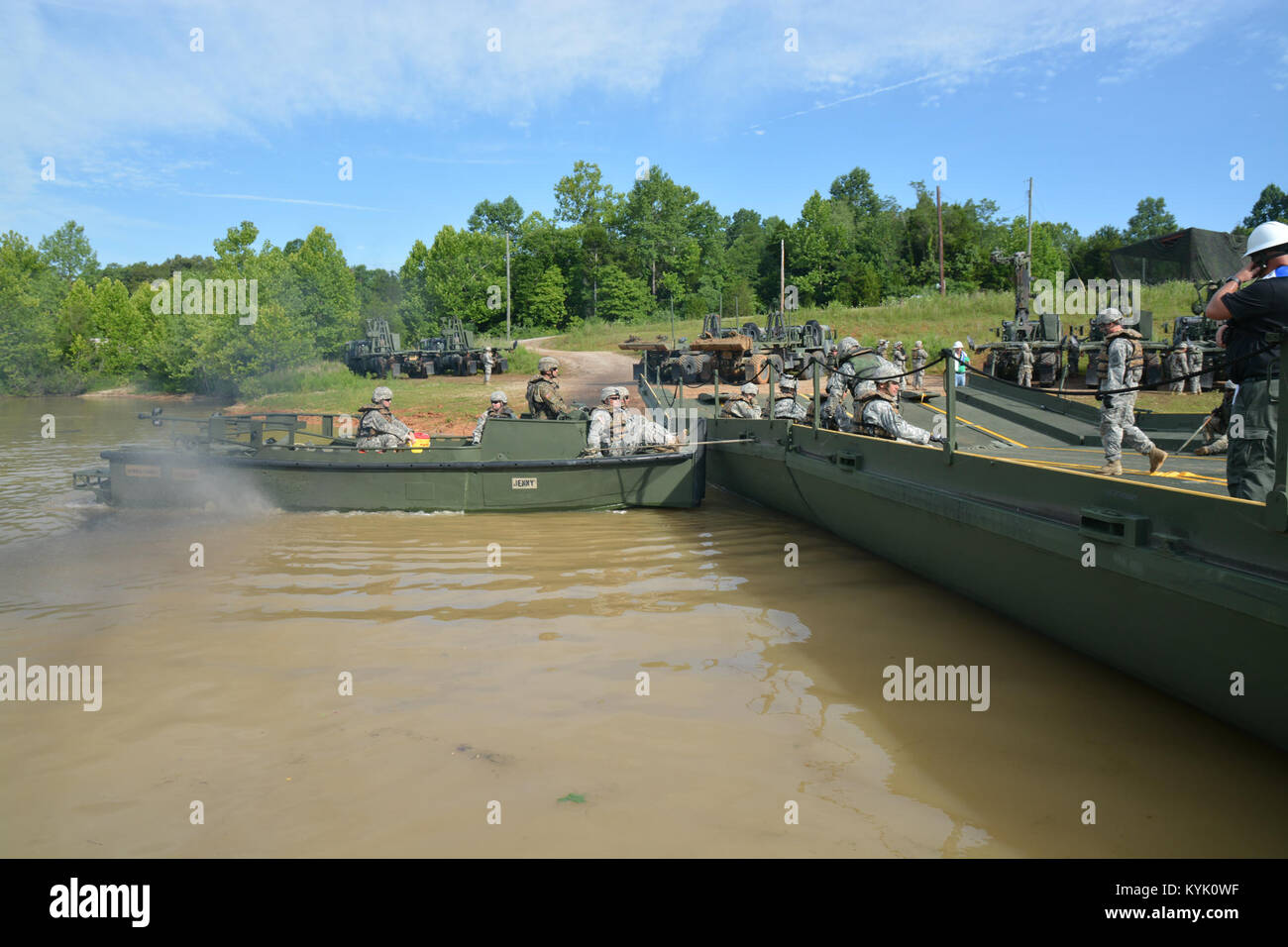 A SSG David Fox of the 2061st Multi Role Bridge Company pilots a MK2 boat to move a float built from an improved ribbon bridge as part of their annual training at Fort Knox Kentucky on 15 Jul 2016. (Kentucky National Guard photo by Walt Leaumont) Stock Photo