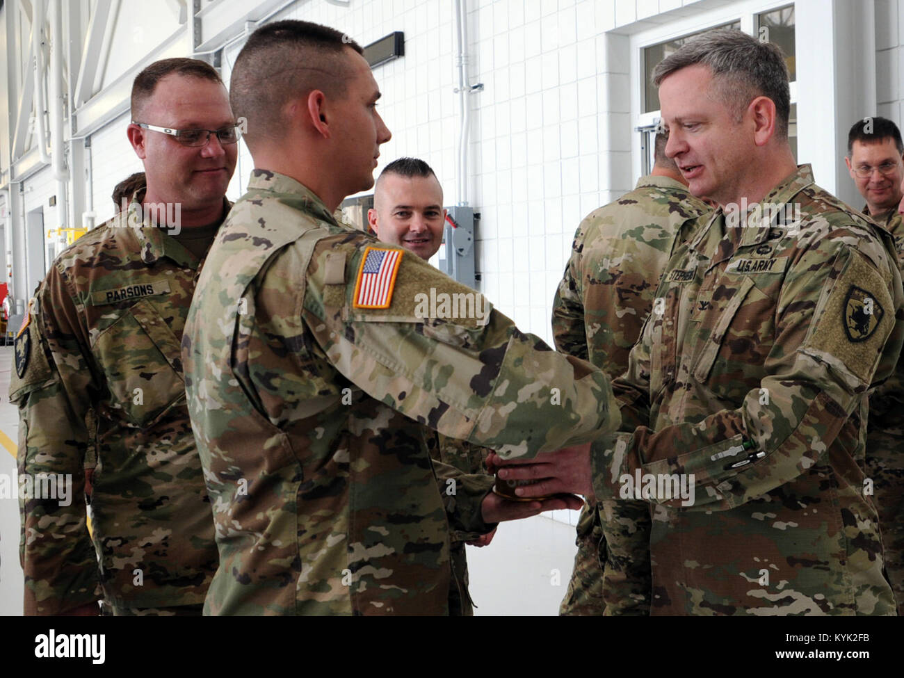 Pvt. Bradley Sampson with the 2123rd Transportation Company presents outgoing commander, Col. Michael Stephens with an expended shell from the live fire during a change of command ceremony held in Frankfort, Ky., May 20, 2017. Stock Photo