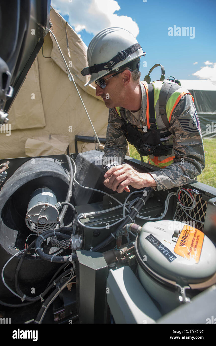Tech. Sgt. Dustin Buel inspects an air conditioning unit serviced by