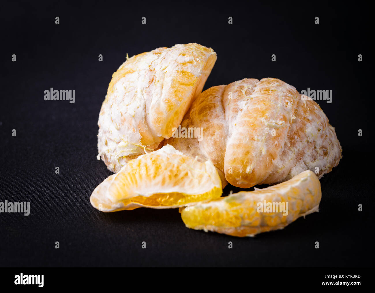 Pieces of an orange mandarin citrus fruit on a balck back ground Stock Photo