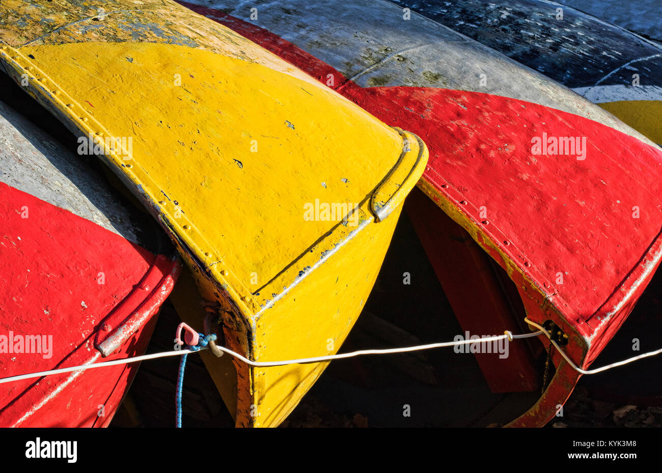 the hulls of upturned brightly coloured boats Stock Photo