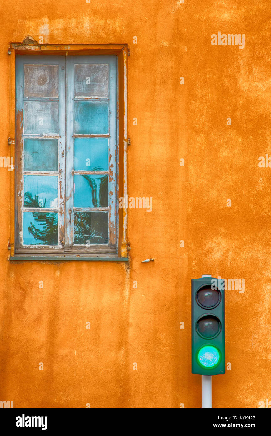 Green Traffic Light In Front Of Bright Orange Wall With Old