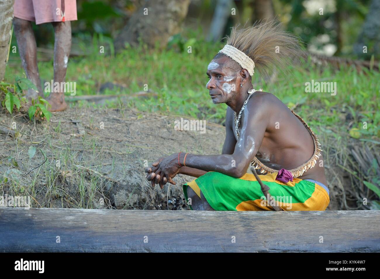 Headhunter of a tribe of Asmat. Traditional facepainting and headdress. Stock Photo