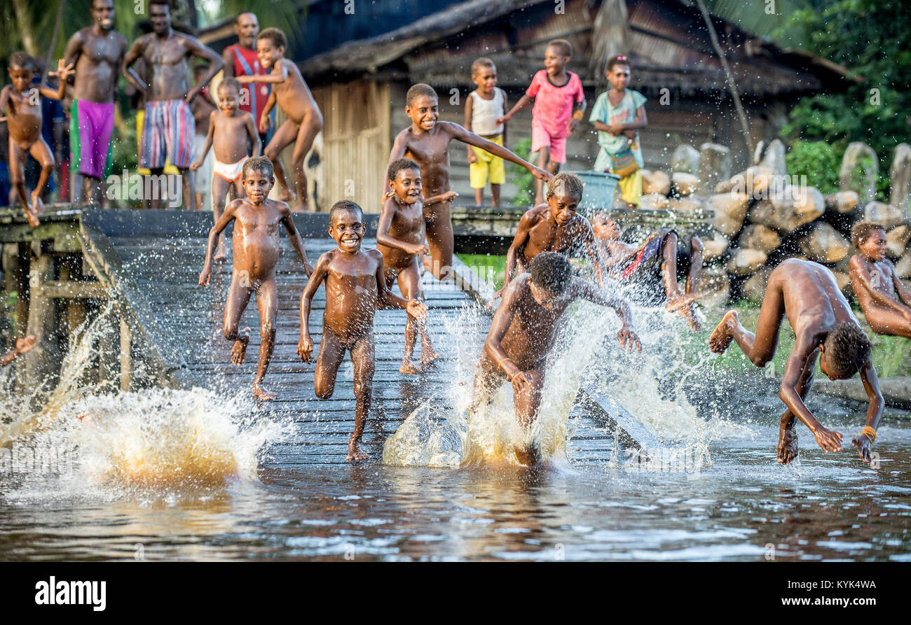 Noisy fun kids. Children of the tribe of Asmat people bathe and swim in