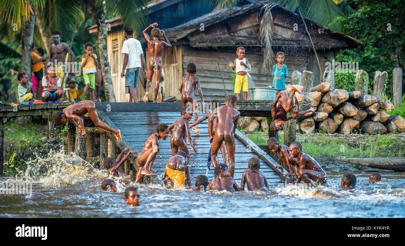 Noisy fun kids. Children of the tribe of Asmat people bathe and swim in the river. New Guinea.May 23, 2016 Stock Photo