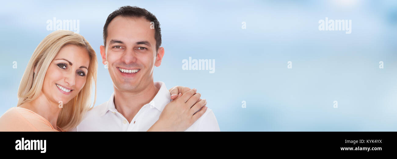 Portrait Of Smiling Young Couple Against Blue Sky Stock Photo - Alamy