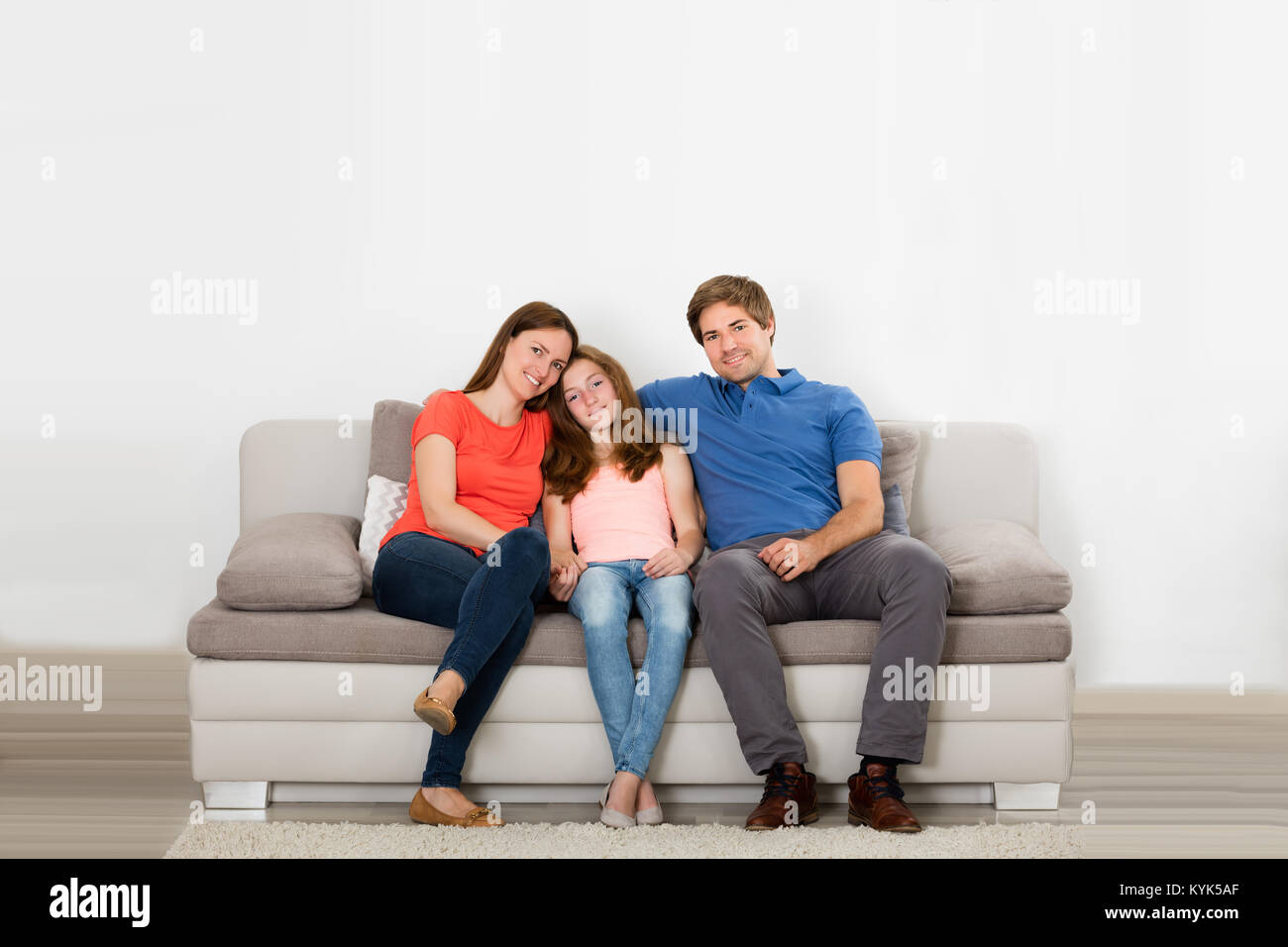 Portrait Of Happy Family Sitting On Couch In Living Room Stock Photo ...
