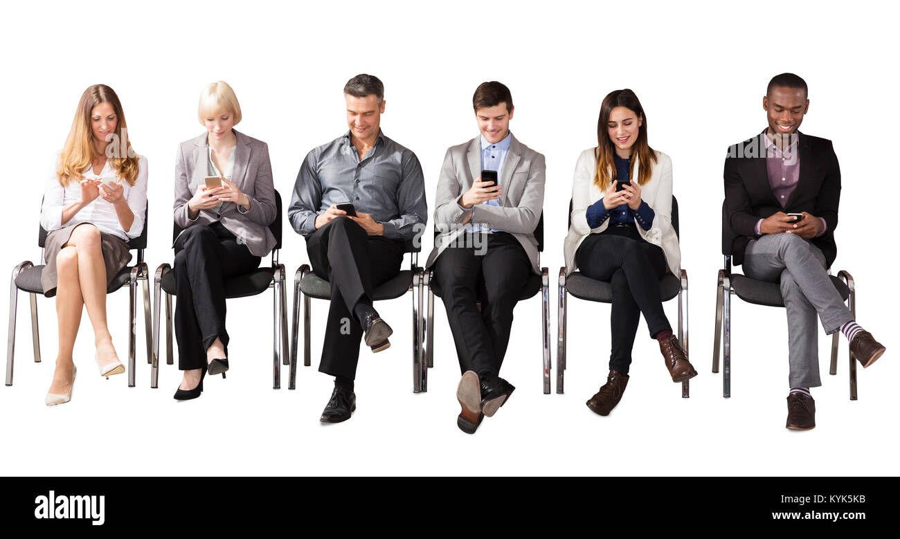 Group Of Multi Ethnic Business People Sitting On Chair Using Cell Phone