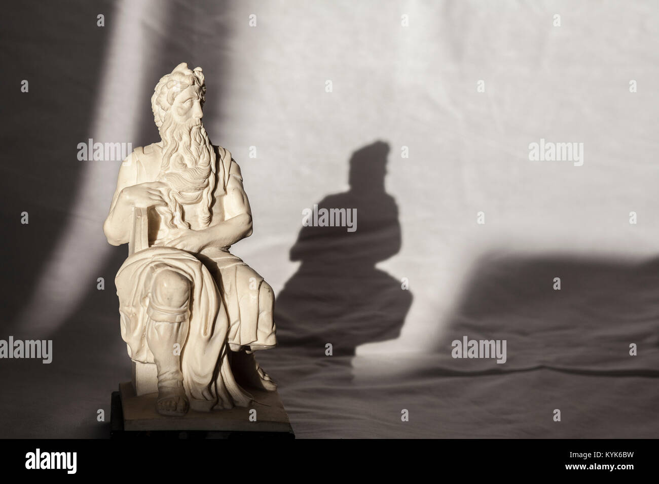 Replica of Michelangelo Moses sculpture, very popular as Rome souvenir. Studio take over wrinkled white fabric Stock Photo
