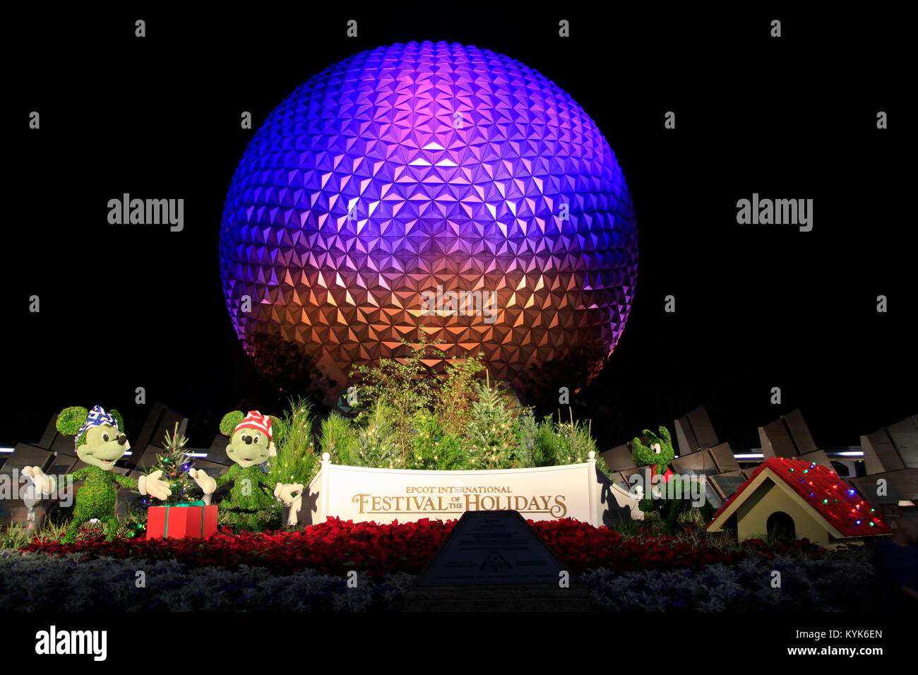 Disney's EPCOT Center sphere illuminated at night during Holidays Season with Mickey Mouse, Minnie and Pluto characters grass sculptures in front. Stock Photo