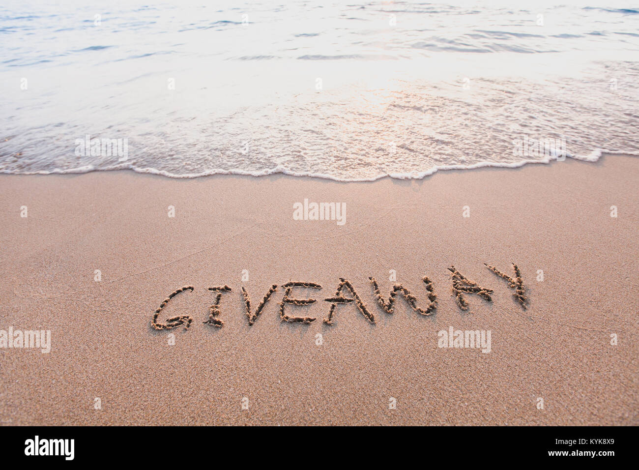 giveaway concept, word message written on the sand Stock Photo