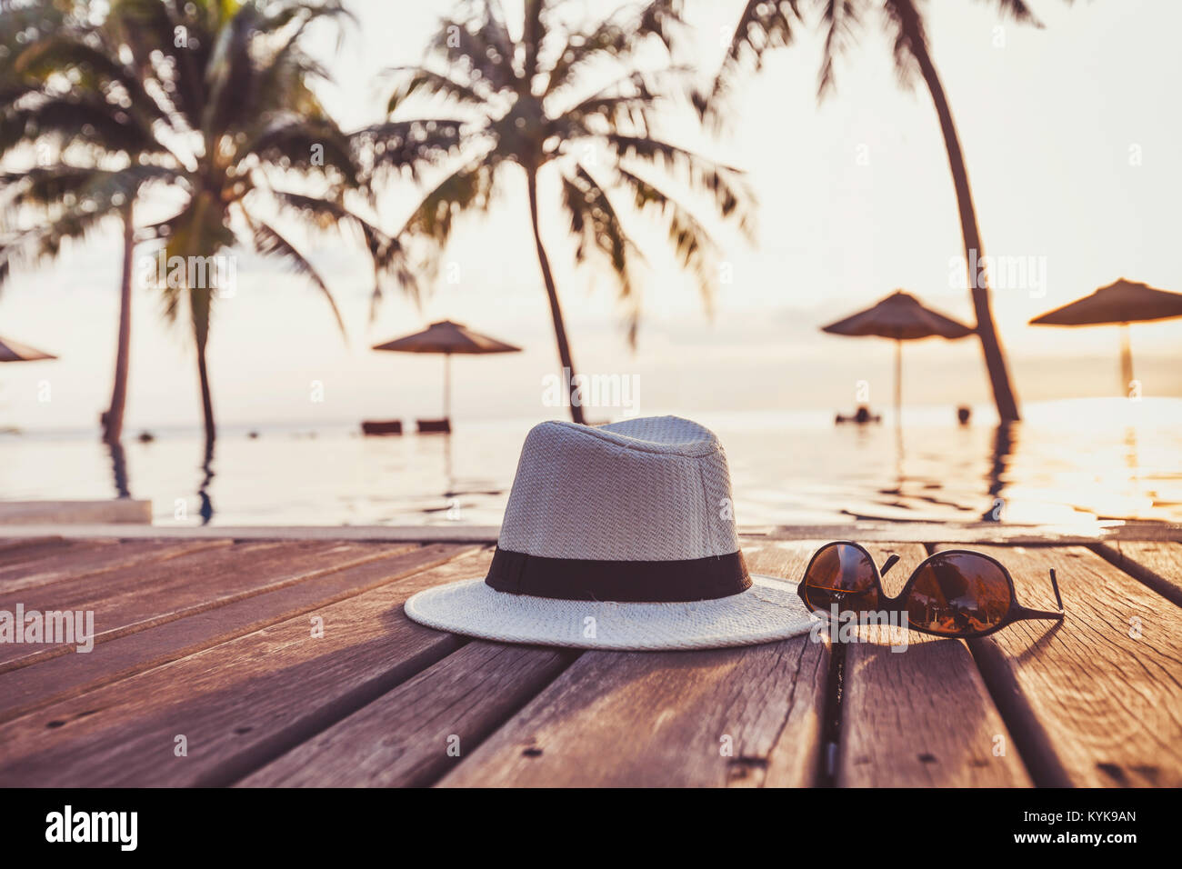 travel and tourism concept, sunglasses and hat near tropical swimming pool, beach holidays Stock Photo