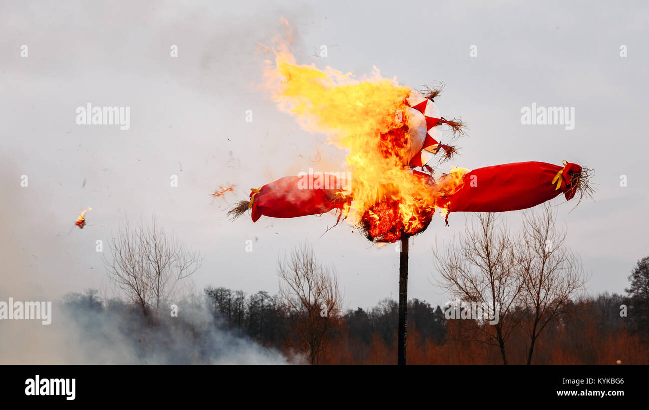 Burning effigies straw Maslenitsa in fire on the traditional holiday dedicated to the approach of spring - Slavic celebration Shrovetide. Stock Photo