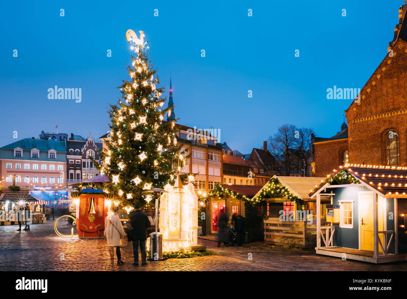 Riga, Latvia. Xmas Market On Dome Square. Christmas Tree And Trading Houses. Famous Landmark In Winter Evening Night In Illuminations Festive Lighting Stock Photo