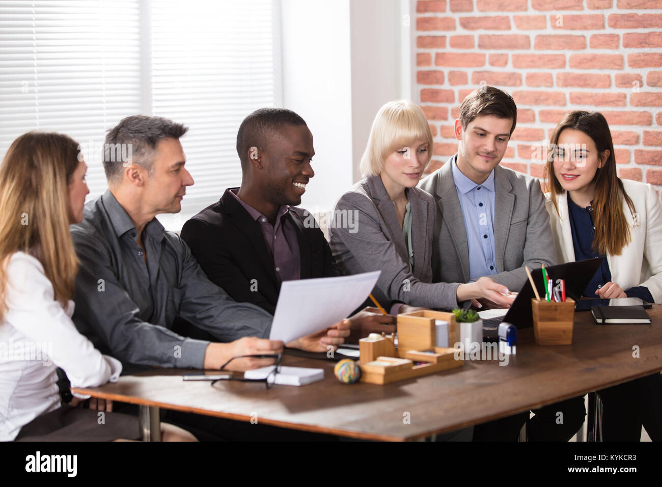Colleague Looking At Laptop In Office Meeting Stock Photo - Alamy