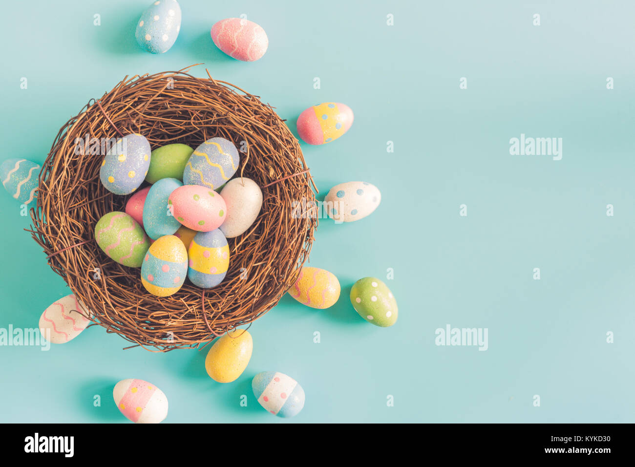 Coloeful easter eggs in nest on pastel color background with space ...