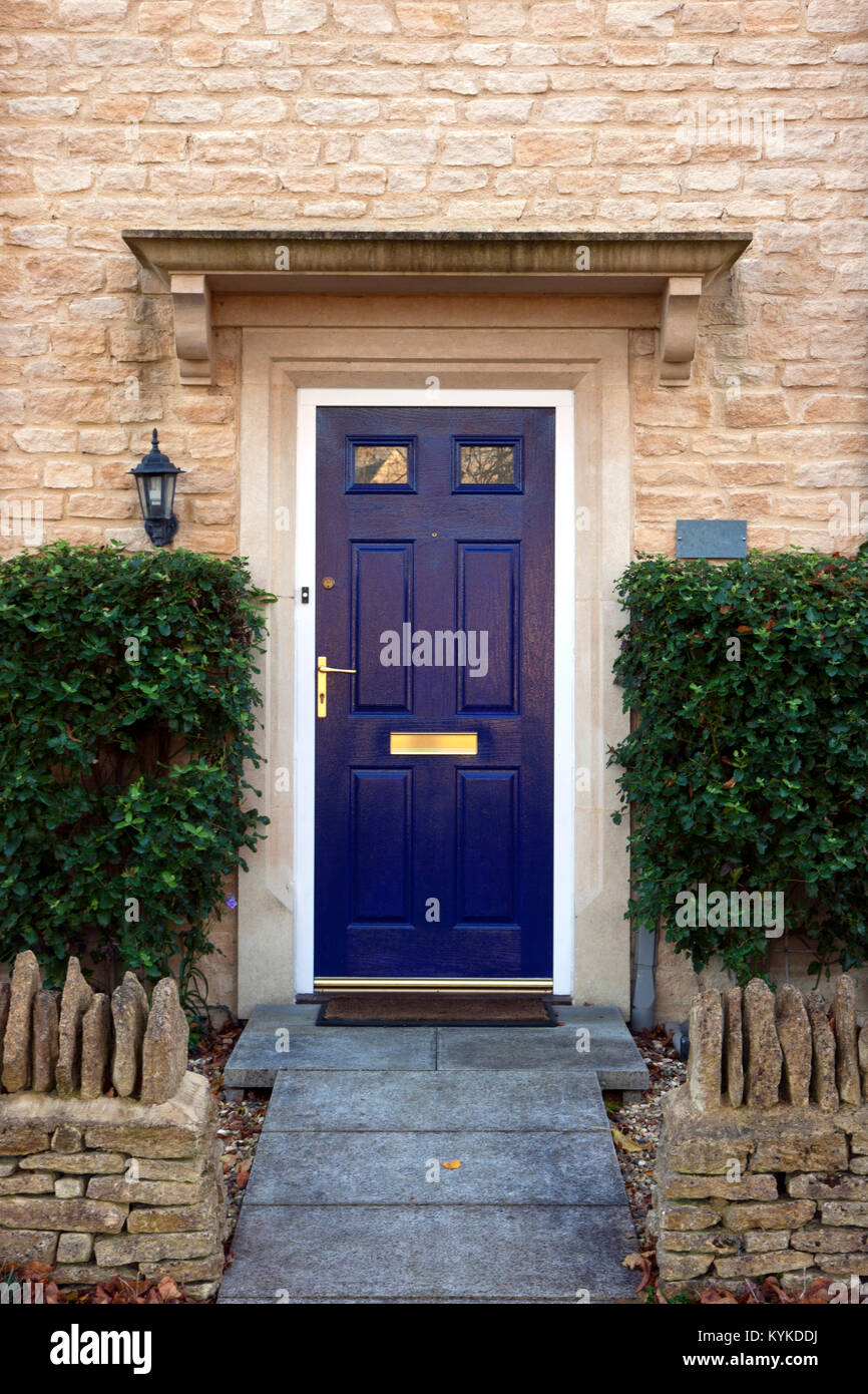 Modern Blue Painted Front Door Flanked By Shrubs Stock Photo