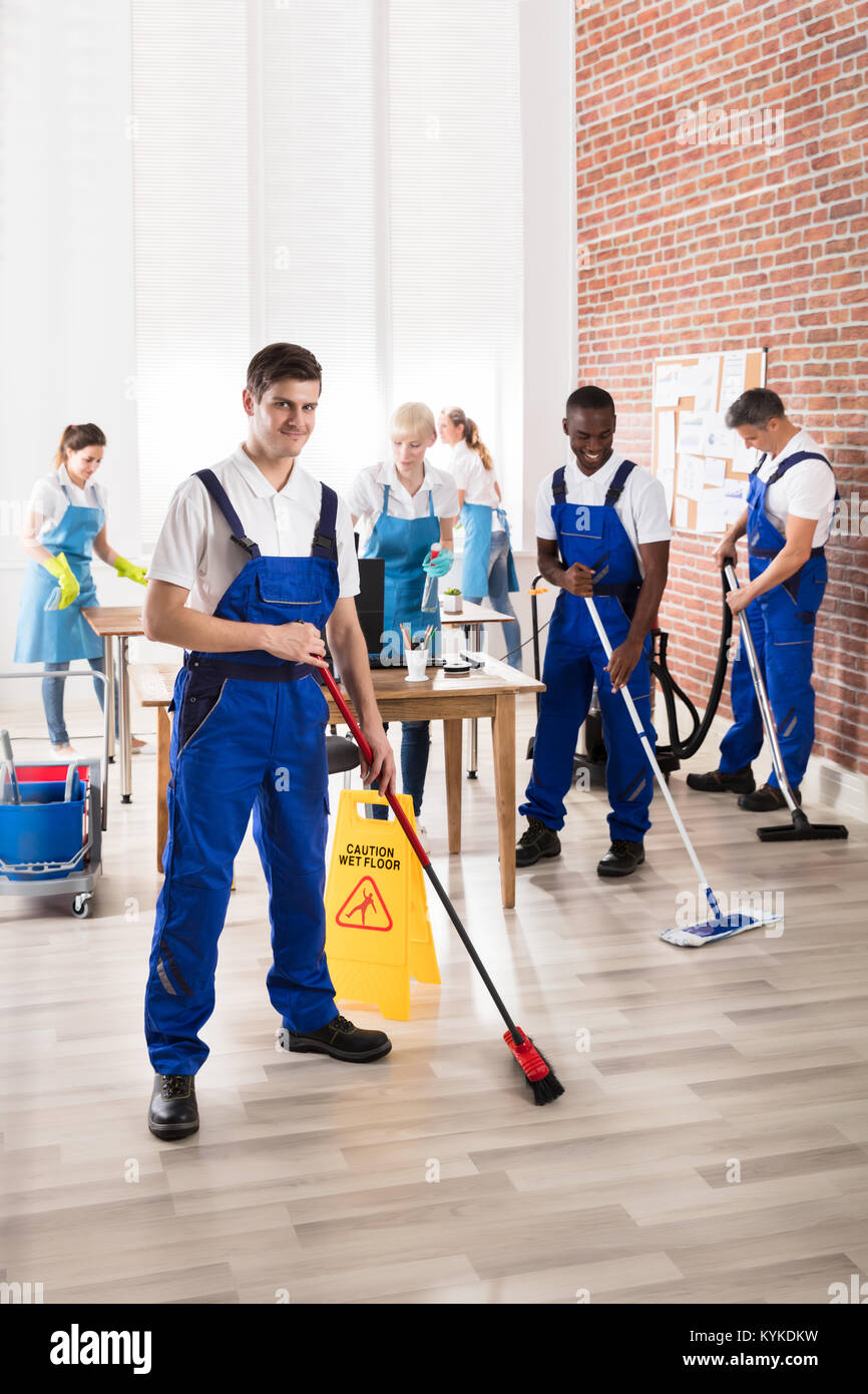 Group Of Diverse Janitors In Uniform Cleaning The Office With Cleaning