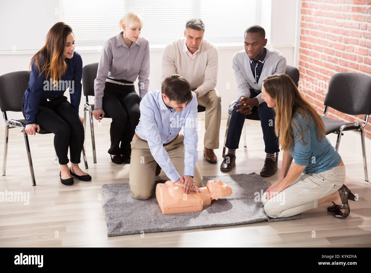 First Aid Instructor Showing Resuscitation Technique On Dummy Stock