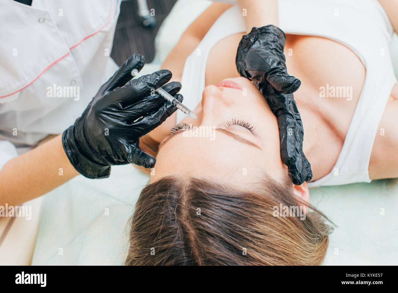 Plastic Surgery. Closeup Of Beautician Hands Holding Syringe Near Female Facial Skin Doing Injections.  Cosmetology. High Resolution. Cosmetology Stock Photo