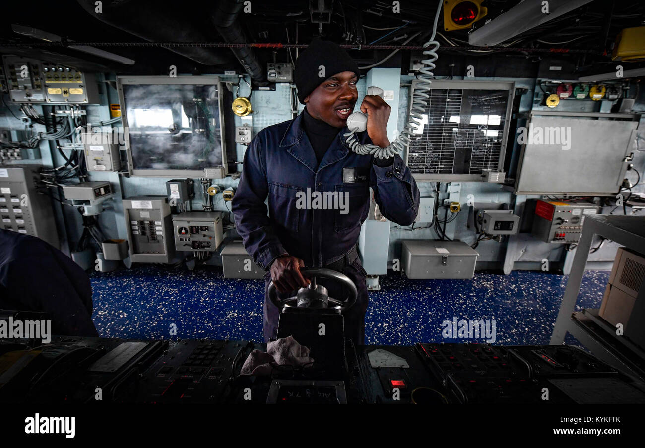 ATLANTIC OCEAN (Nov. 1, 2017) Seaman Namib Baregu mans the helm of the Arleigh Burke-class guided-missile destroyer USS Oscar Austin (DDG 79). Oscar Austin is on a deployment supporting U.S. national security interests in Europe, and increasing theater security cooperation and forward naval presence in the U.S. 6th Fleet area of operations. (U.S. Navy photo by Mass Communication Specialist 2nd Class Ryan Utah Kledzik/Released)171101-N-UY653-076 Stock Photo