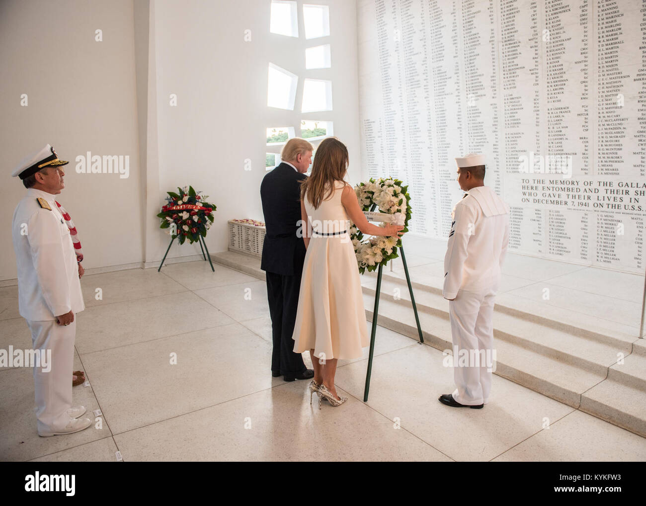 171103-N-ON707-197 PEARL HARBOR, Hawaii (Nov. 3, 2017) U.S. Pacific Command (USPACOM) Commander, Adm. Harry Harris, observes President Donald J. Trump and First Lady Melania Trump as they present a wreath in honor of fallen service members at the USS Arizona Memorial. The President is in Hawaii to receive a briefing from USPACOM prior to traveling to Japan, the Republic of Korea, China, Vietnam and the Philippines from November 3-14. During the trip the President will underscore his commitment to longstanding U.S. alliances and partnerships, and reaffirm U.S. leadership in promoting a free and Stock Photo