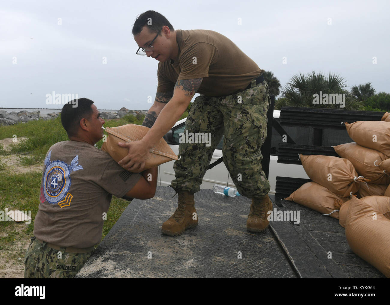 MAYPORT, Fla. (Sept. 6, 2017) Command Master Chief Johannes Gonzales, left, and Logistics Specialist 1st Class Jesus Manriquez, both assigned to U.S. Naval Forces Southern Command/U.S. 4th Fleet (USNAVSO/FOURTHFLT) stack sand bags into a truck to pre-stage them around USNAVSO/FOURTHFLT headquarters in preparation for Hurricane Irma. (U.S. Navy photo by Mass Communication Specialist 2nd Class Michael Hendricks/Released) 170906-N-PQ607-031 Stock Photo