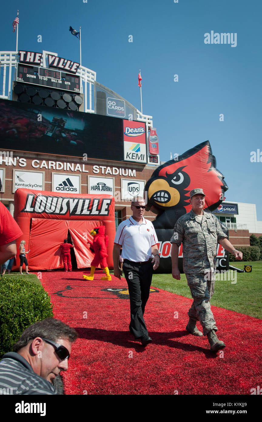 Kentucky’s adjutant general, Maj. Gen. Edward Tonini (right), walks onto the field at Papa John’s Cardinal Stadium in Louisville, Ky., Sept. 7, 2013, as part of Military Appreciation Day events held in conjunction with the University of Louisville-Eastern Kentucky University football game. Tonini executed the coin toss to begin the game. (U.S. Air National Guard photo by Maj. Dale Greer) Stock Photo