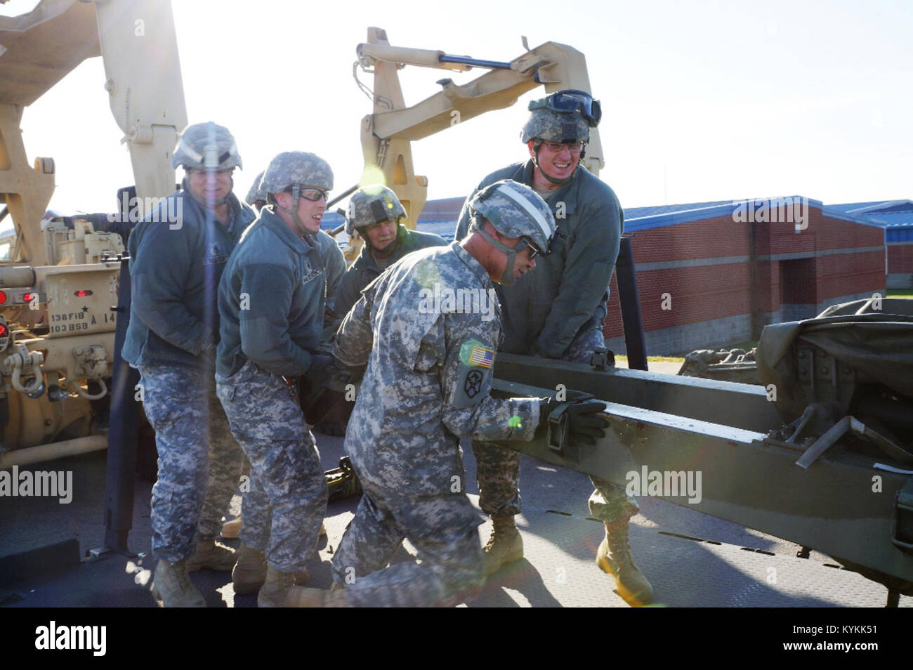 Soldiers work together unloading a 105-millimeter howitzer canon prior ...
