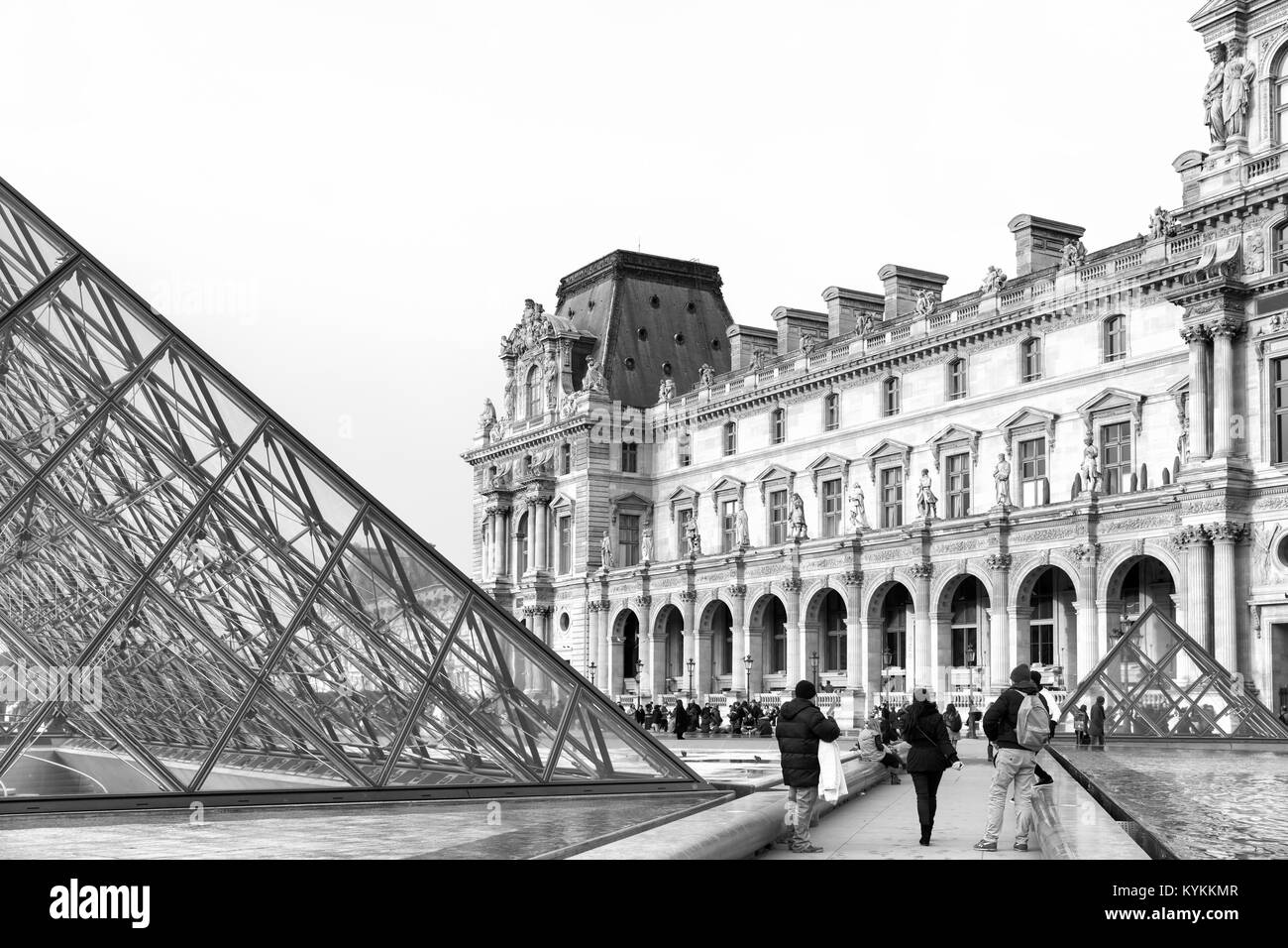 PARIS-Jan 5, 2014: Louvre Museum courtyard and glass pyramid. Black and white daytime image. Stock Photo