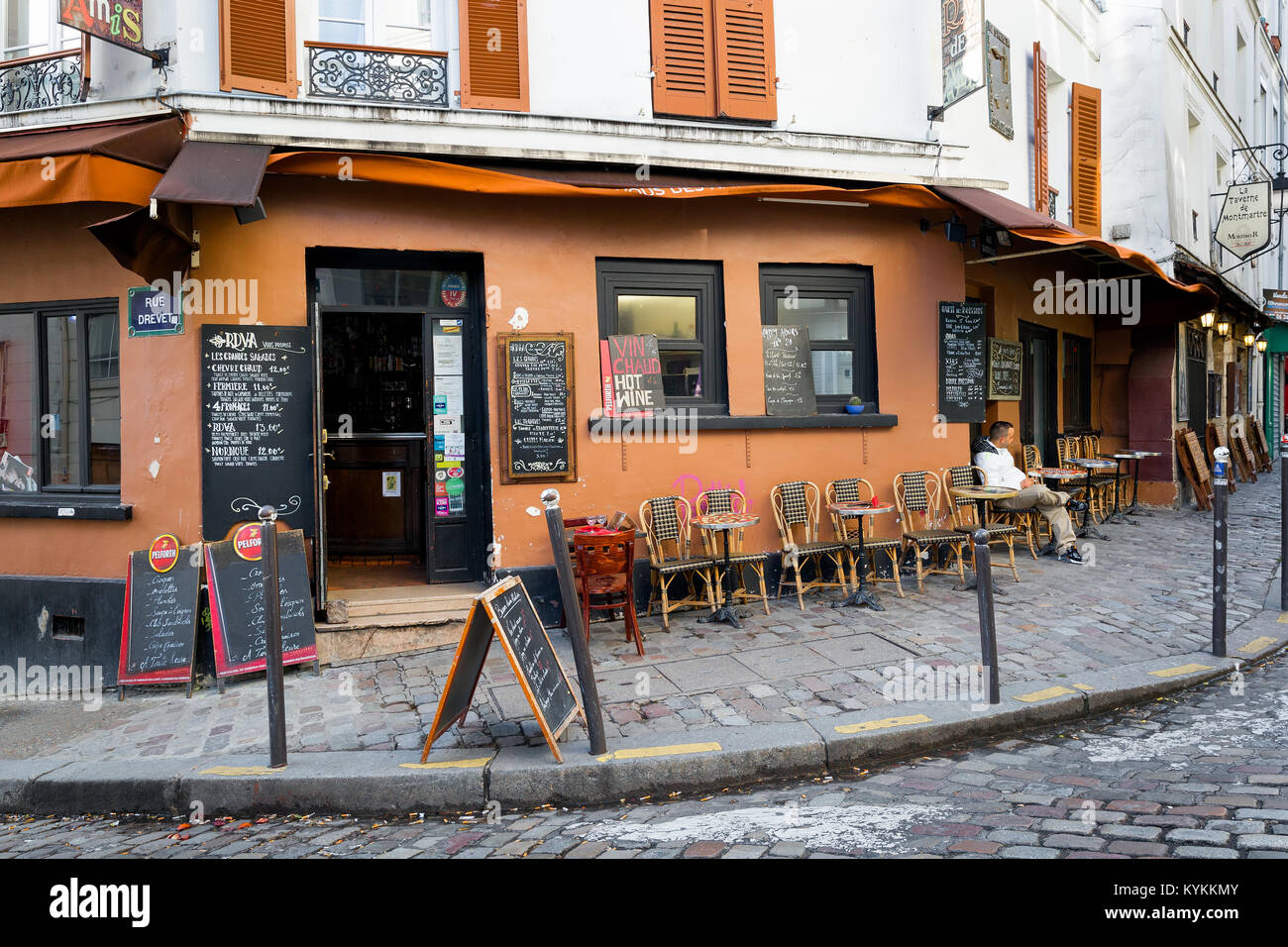 PARIS - Jan 2, 2014: Cafe in the Montmartre neighborhood. Typical place with sidewalk tables and handwritten menus. Stock Photo